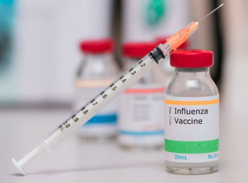 influenza vaccination concept with syringe in vaccine vial and o